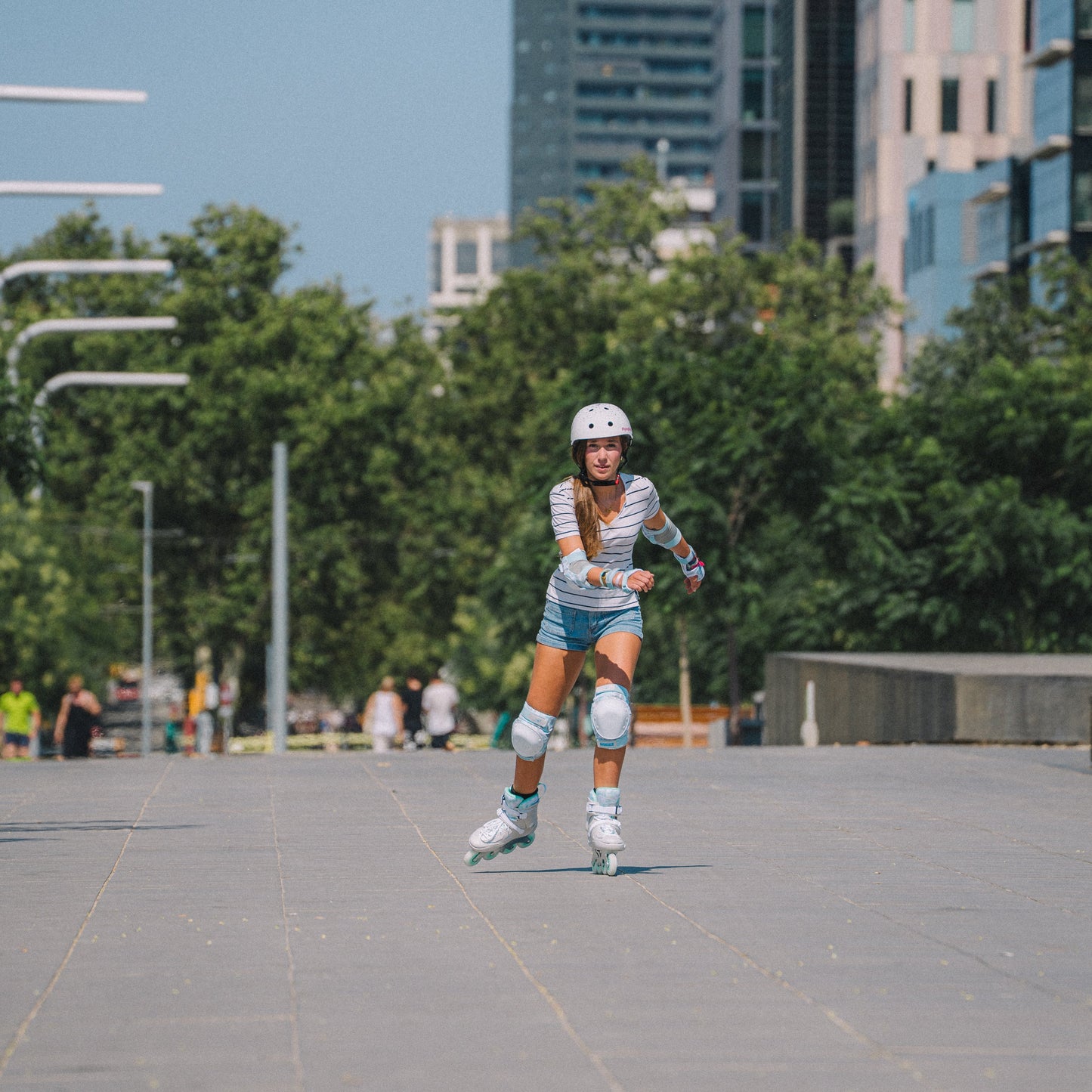 Outdoor model shot with Flying Eagle SHRIKE mint inline skates, withURBAN White Stars skate helmet, balanced comfort performance for all skill skaters