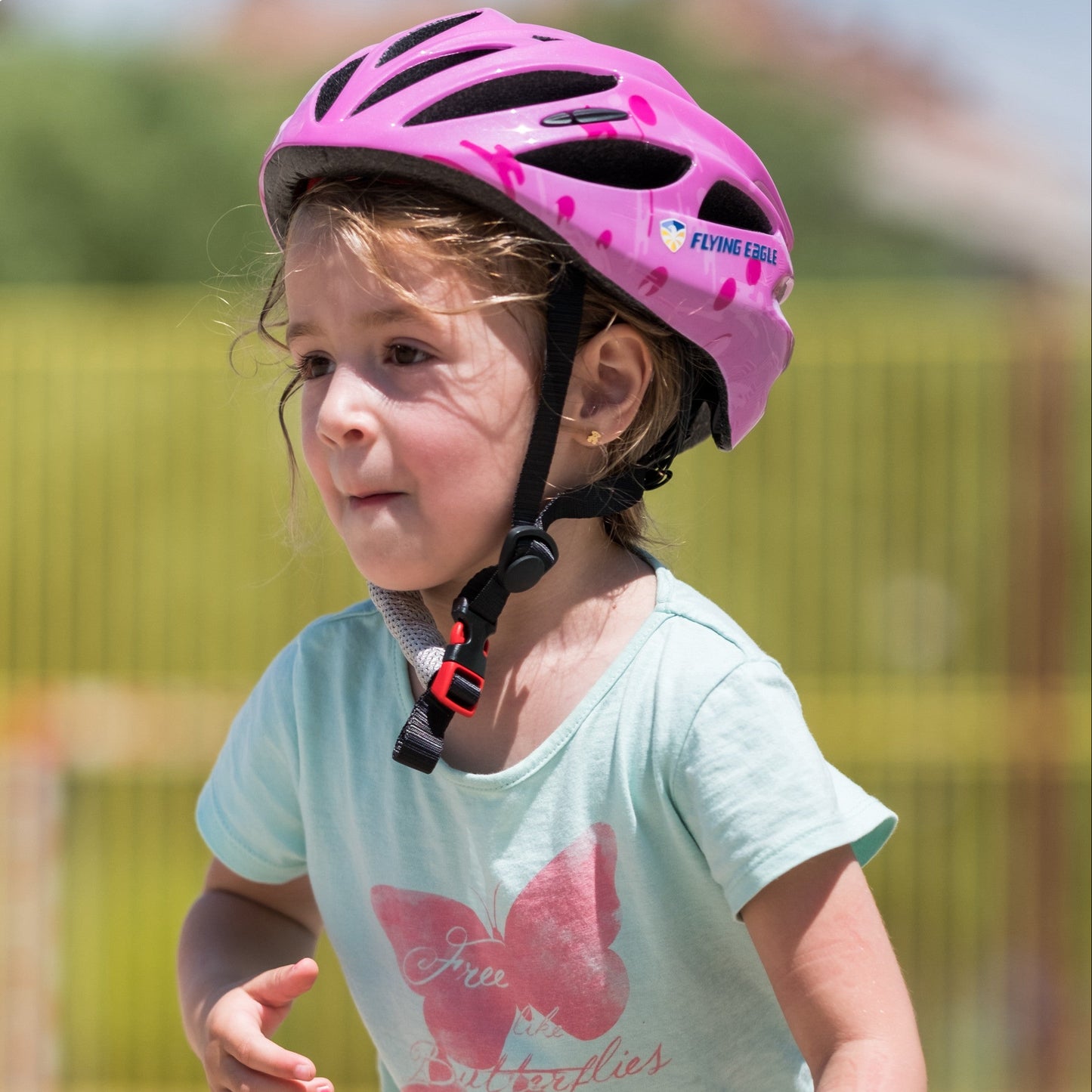 Little skater in FlyingEagle RAPIDO JR helmet enjoying skateboarding at outdoor park