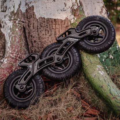 FlyingEagle TERRA FRAMES black leaning against a tree in an outdoor setting