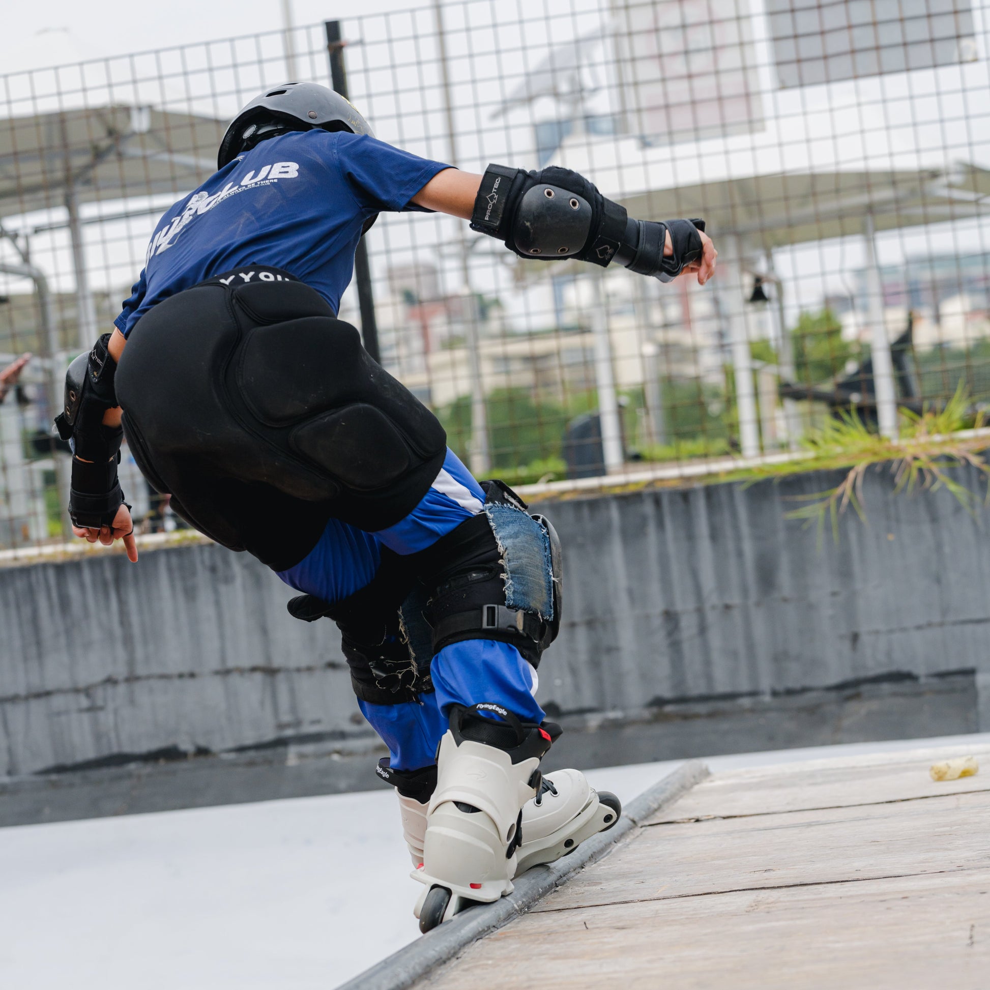 Young skater in FlyingEagle white VIREO adjustable inline skates, extreme moves in bowl ramp