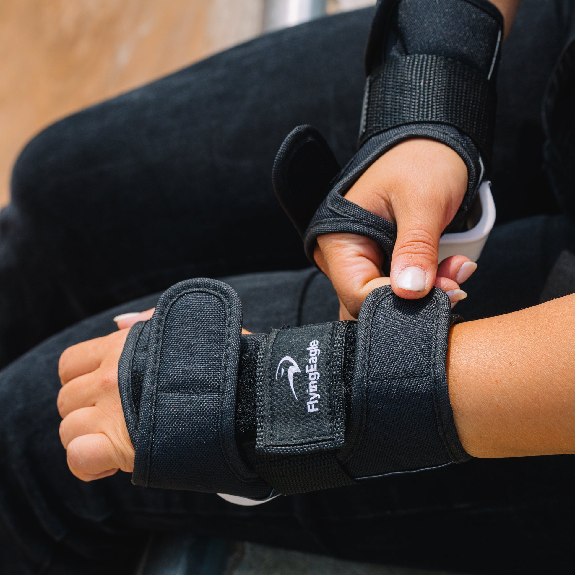 Skater putting on FlyingEagle CORE Wrist Guards for street and park inline skating