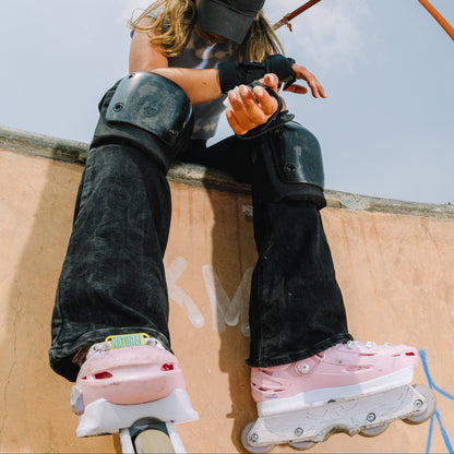 Skater putting on FlyingEagle PRO knee pads for safe street and park inline skating