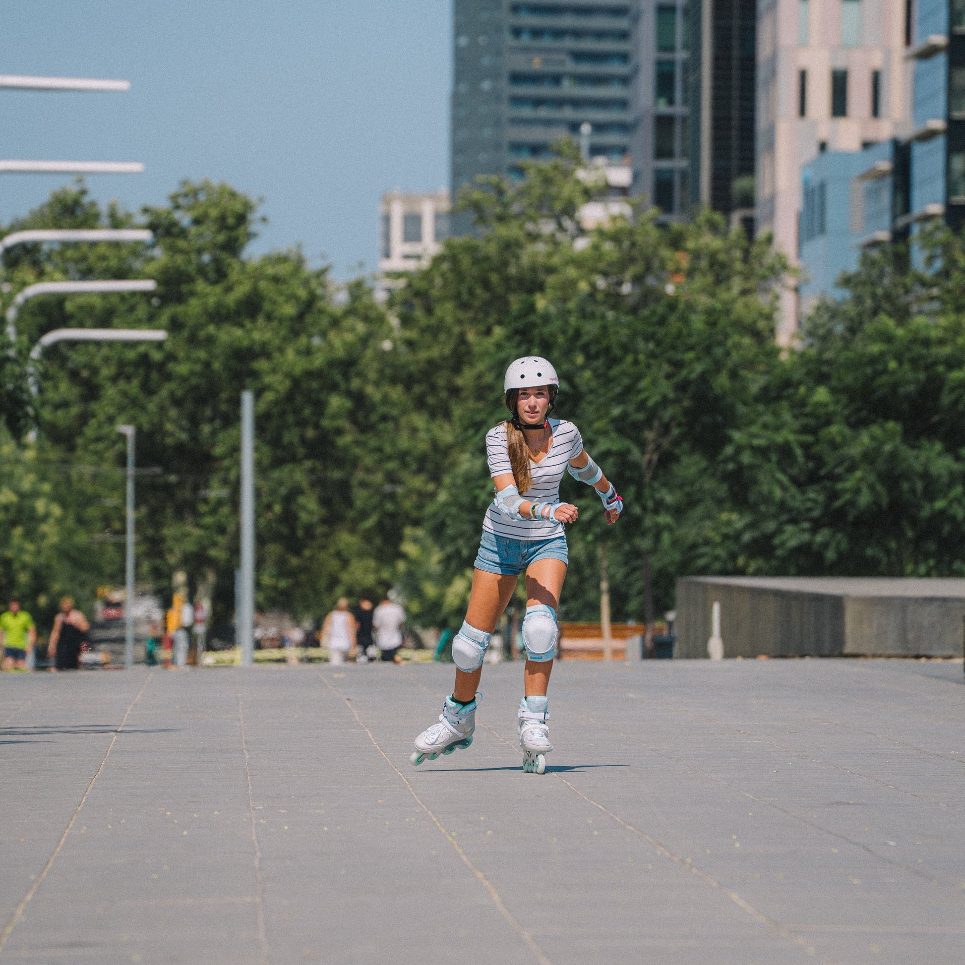 Outdoor model shot with Flying Eagle SHRIKE mint inline skates, withURBAN White Stars skate helmet, balanced comfort performance for all skill skaters