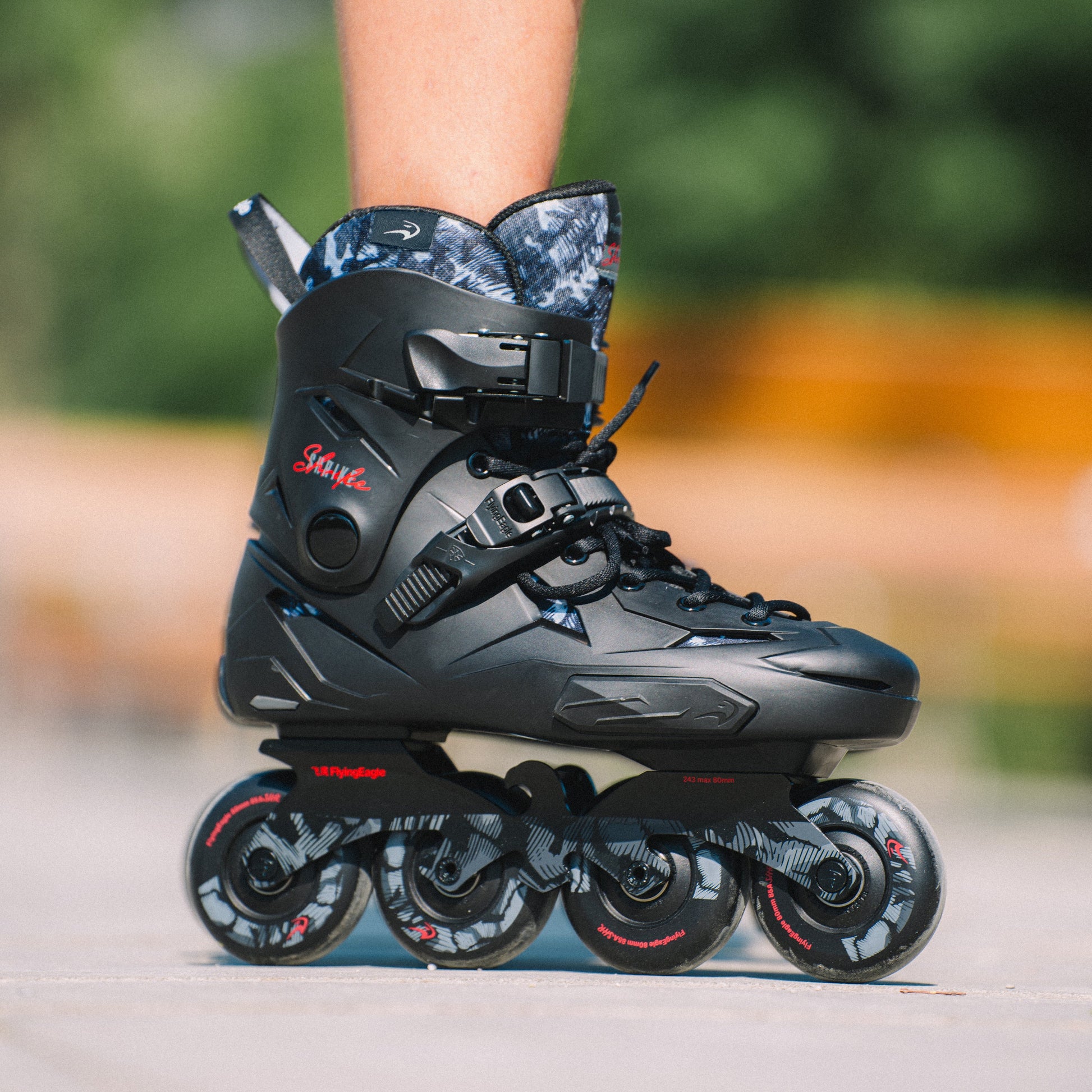 Close shot of feet wearing Flying Eagle SHRIKE black adult inline skates EU36-46 stylish hard boot urban skate display