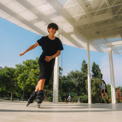 Model displaying Flying Eagle SHRIKE black hard shell inline skates, comfortable performance skate for all skill levels