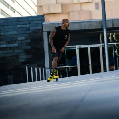 Skater with protective gear gliding on urban street with Flying Eagle REAVER S7680 Yellow Black adult inline skates 4 wheels 85A rockerable axles