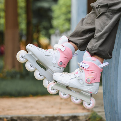 A close-up lifestyle shot of a person's legs dangling over a blue railing in an outdoor park, wearing Flying Eagle SHRIKE SE peony pink 3‑wheel urban inline skate