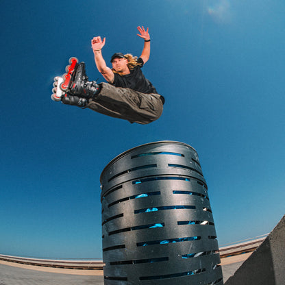 Person on rollerblades performing a trick above a cylindrical object with  Flying Eagle RAVEN inline skate