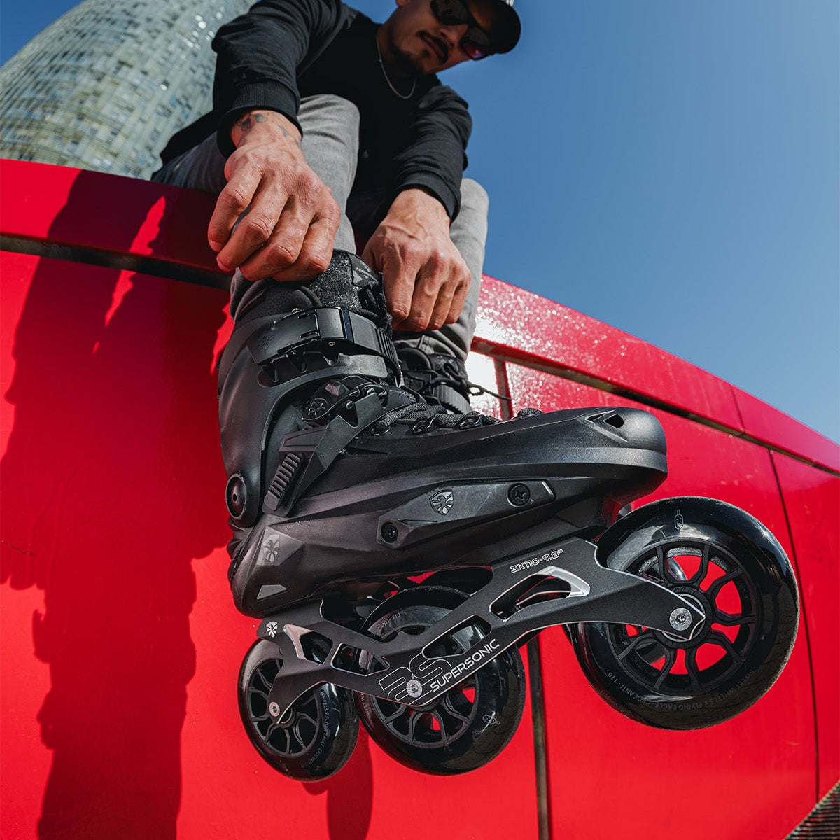 Person adjusting Black FlyingEagle REAVER TRI on a red surface.