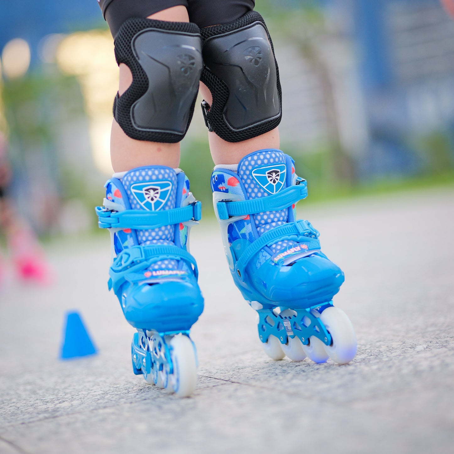 Person wearing Blue FlyingEagle LUMAFLY inline skates with knee pads outdoor