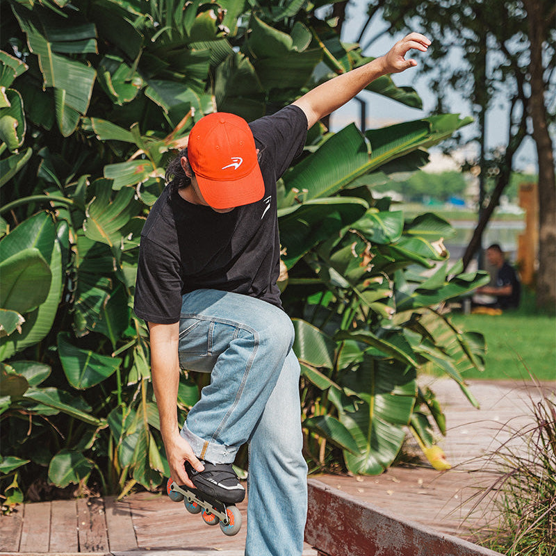 Skater wearing FlyingEagle ICON CAP cotton hat while doing inline skating tricks outdoors