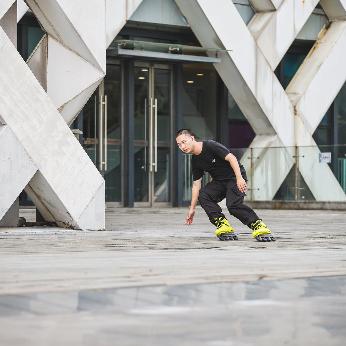 Skater with protective gear gliding on urban street with Flying Eagle REAVER S7680 Yellow Black adult inline skates 4 wheels 85A rockerable axles
