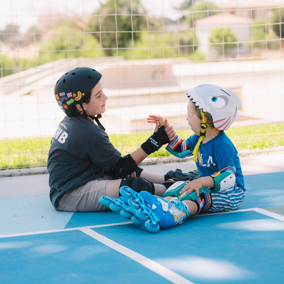 Child wearing FlyingEagle RIDER helmet andFlying Eagle  black kids inline skates doing urban skating outdoors