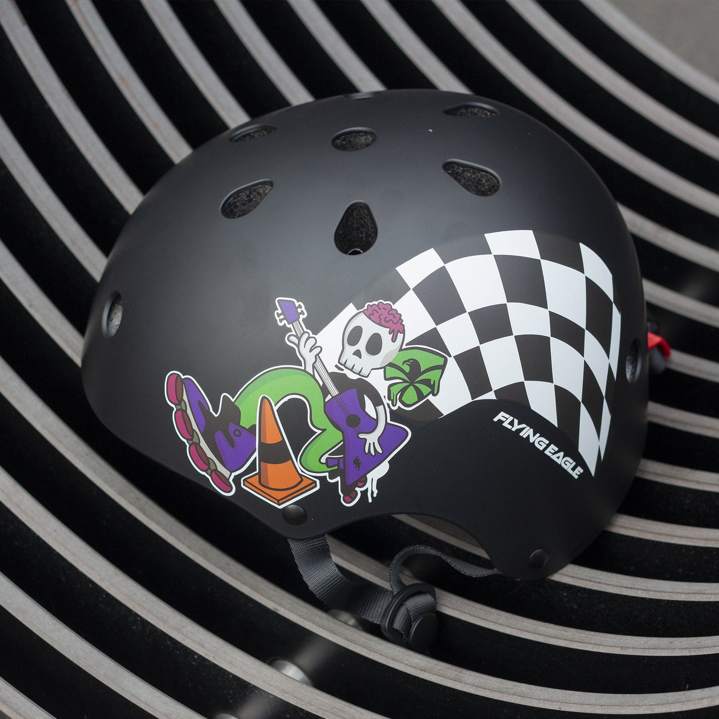 FlyingEagle RIDER JR black helmet displayed on kids recreational park surface