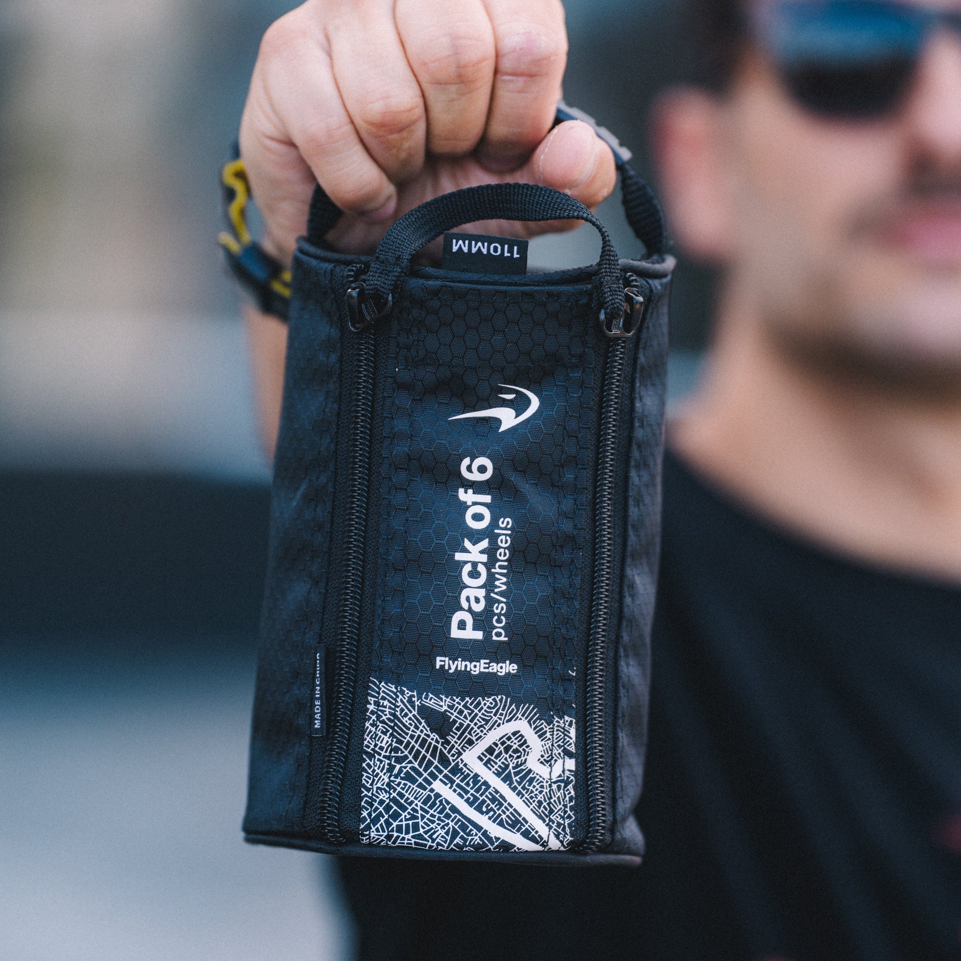 Person holding a Black FlyingEagle double zipper wheel bag
