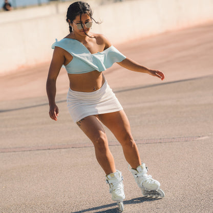 Adult skater riding Flying Eagle AVIAN beige inline skates, practicing freestyle moves on urban flat pavement