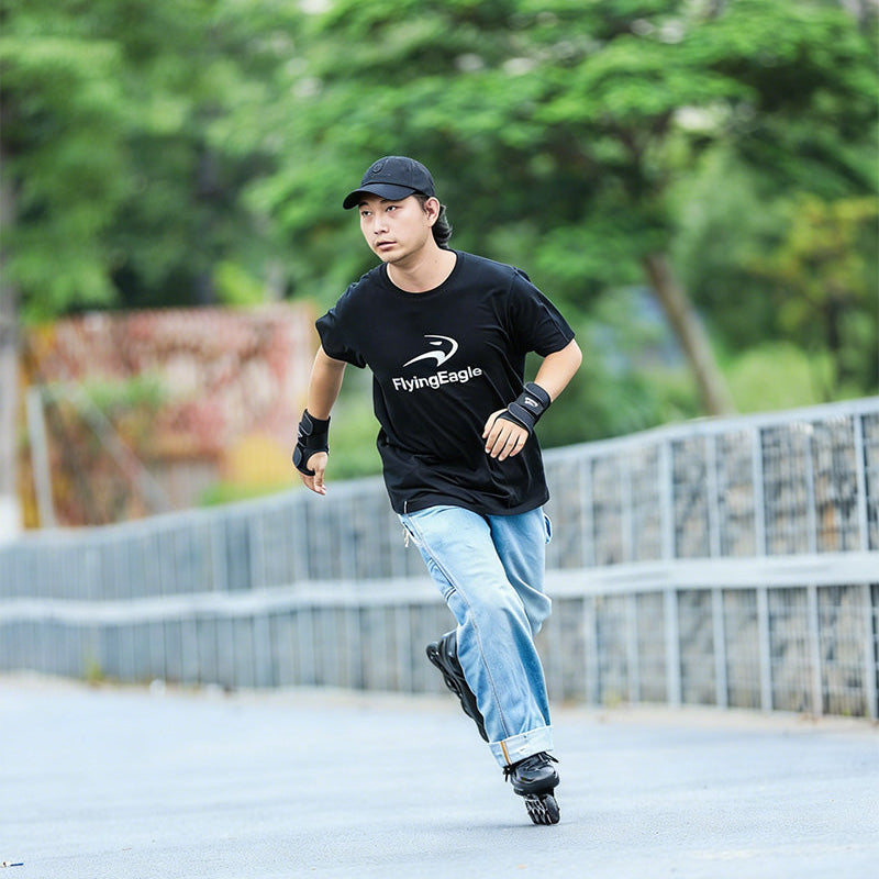 Man in black classic cotton t-shirt performing roller skating moves street sports scene