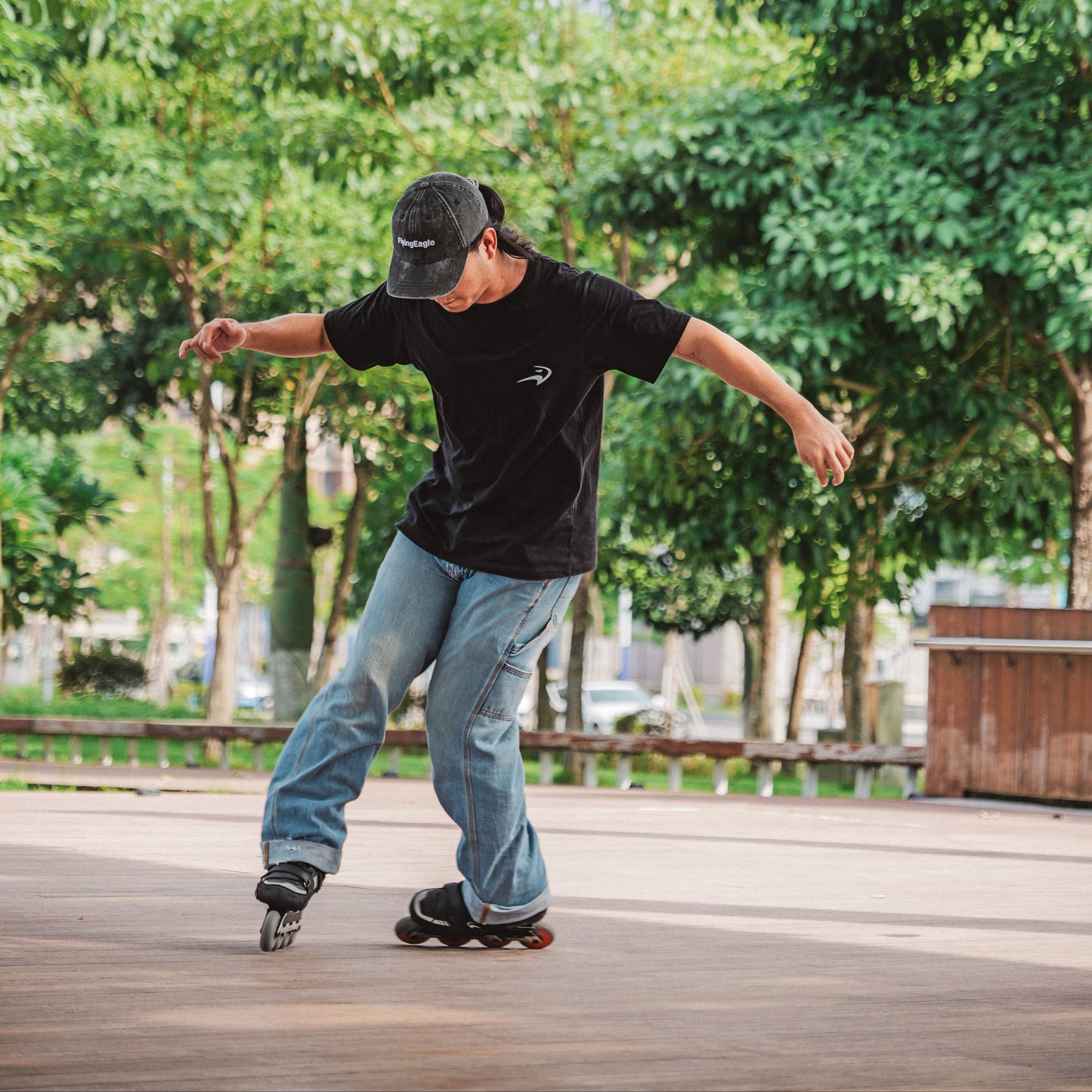 Sports enthusiast in black iconic cotton tee practicing street roller skating tricks