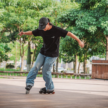 Sports enthusiast in black iconic cotton tee practicing street roller skating tricks
