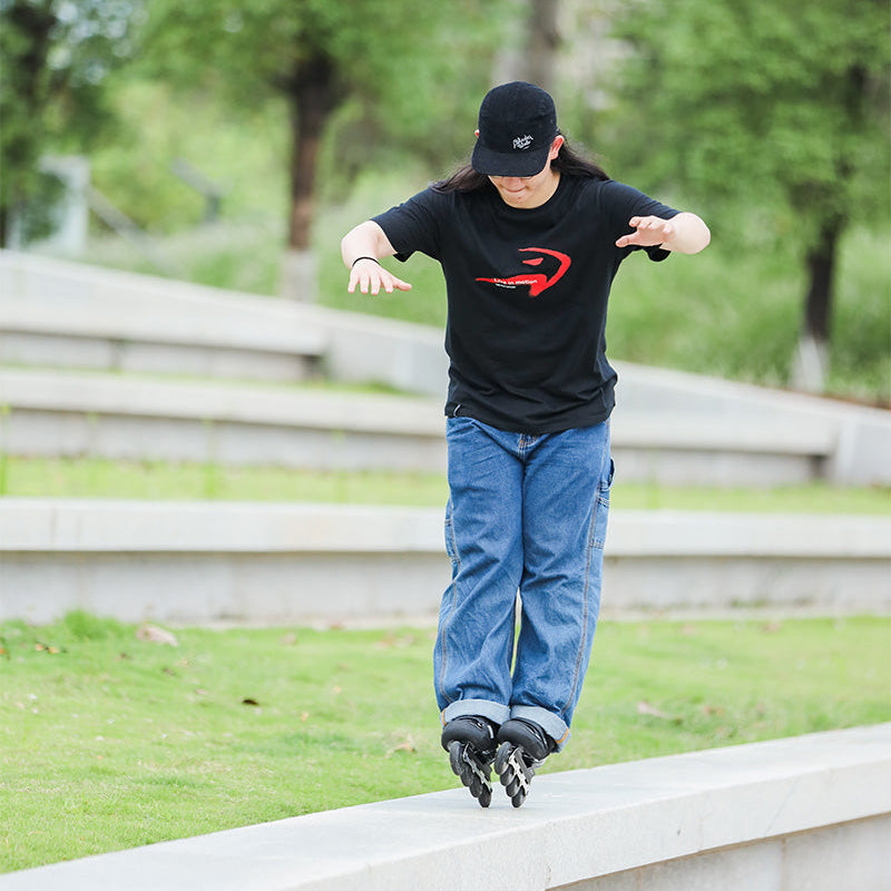 Skater wearing black SPRAYED TSHIRT soft cotton t-shirt practicing outdoor roller skating tricks