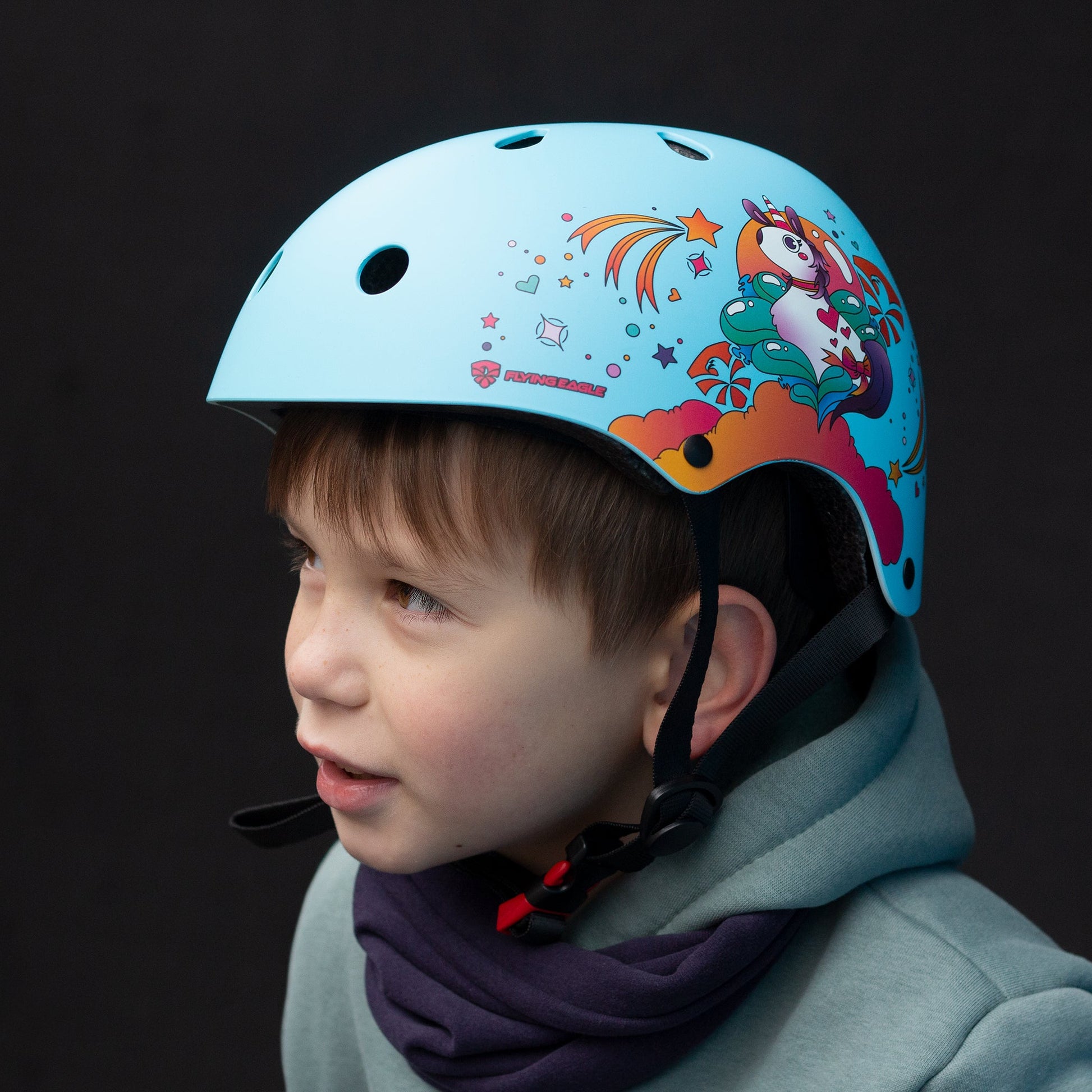 Young child with FlyingEagle RIDER JR blue helmet practicing skateboarding outdoors